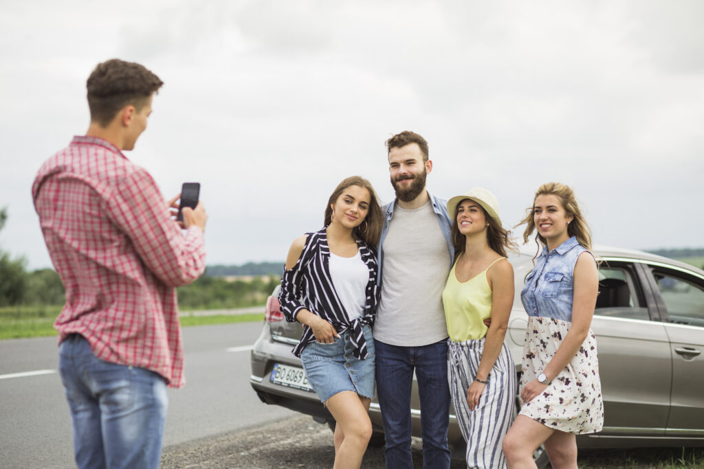 East Coast Family Vacations:
man-taking-picture-his-friends-standing-front-car-road