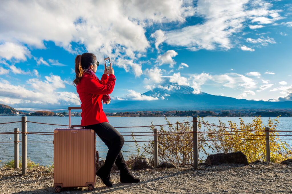 Benefits of Solo Travel: Women take a photo at Fuji mountains. Autumn in Japan. Travel co